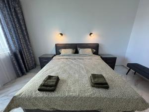 a bedroom with a large bed with two towels on it at Central Park 7 in Burgas City