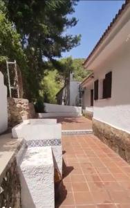 a pair of benches sitting on a sidewalk next to a house at Casa Elviras in Alcossebre