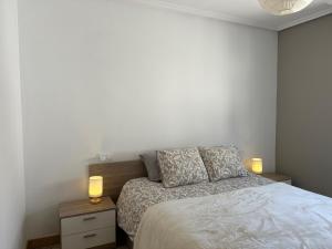 ein Schlafzimmer mit einem Bett mit zwei Lampen in der Unterkunft Apartamento Mirador de Gredos in Madrigal de la Vera