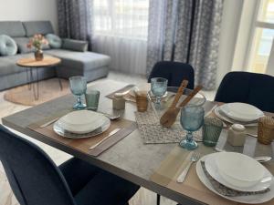 a dining room table with plates and glasses on it at Central Park 7 in Burgas City