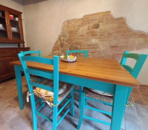 a blue table and chairs in front of a brick wall at La casetta sull'arco in Sarteano +12 photos
