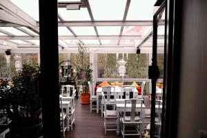 a patio with white chairs and tables on a porch at MarcoPolo House in Warsaw