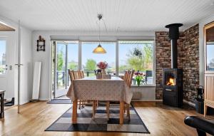 a dining room with a table and chairs and a fireplace at Holiday Home Diernæs Strandby L-675 in Haderslev