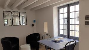 a dining room with a table and chairs and a mirror at Tiny House classée in Maincy