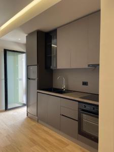 a kitchen with gray cabinets and a sink at Seamare Studio & Apartaments in Vlorë