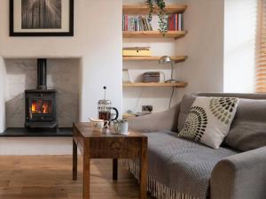 ein Wohnzimmer mit einem Sofa und einem Holzofen in der Unterkunft Charming 2 bed Escape in Snowdonia National Park ! Nr Betws y Coed in Betws-y-coed