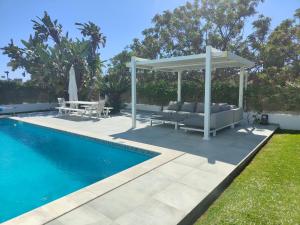 a pergola next to a swimming pool with a patio at Vila orada lola in Albufeira