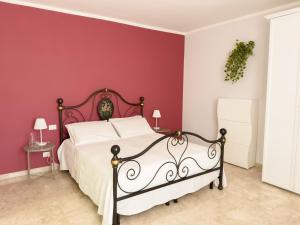 Un dormitorio con una pared roja y una cama. en Casa Romualdo, en Monopoli