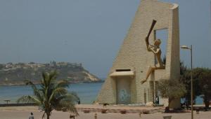 a statue of a woman on a building next to the ocean at Furnished studio for rent in city in Dakar