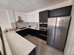 a kitchen with a stainless steel refrigerator and black cabinets at Furnished studio for rent in city in Dakar