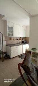 a kitchen with white cabinets and a chair in it at Cottage sul golfo in Lerici
