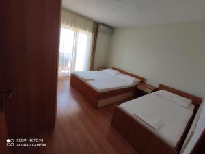 a small room with two beds and a window at Apartmani Erlic in Turanj