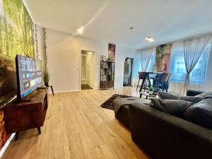 a living room with a couch and a flat screen tv at Apartment-Am-Stadtbrunnen,50m2,Küche,2 Schlafzimmer,Kfz Parkplatz,Terrasse,Waschmaschine in Cottbus