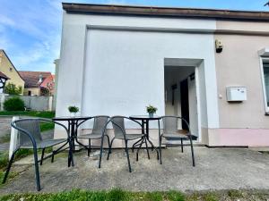 a black table and chairs in front of a white building at Apartment-Am-Stadtbrunnen,50m2,Küche,2 Schlafzimmer,Kfz Parkplatz,Terrasse,Waschmaschine in Cottbus +2 photos