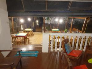 an empty room with tables and chairs and lights at New Born Restaurant & Accommodation in Hikkaduwa