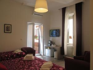 Un dormitorio con una cama y una silla y una ventana. en Trevi Elegance Suite, en Roma