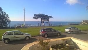 tres autos estacionados en un estacionamiento cerca del océano en The Southcliff Hotel, en Folkestone