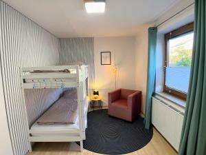 a small room with a bunk bed and a chair at 4 Zimmer Wohnung, 6 Bed, Küche, Waschmaschine, Wlan, Garden, free Parking in Tacherting