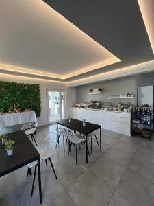 a living room with tables and chairs and a kitchen at Innova TravelVir - Salt and Sun in Vir