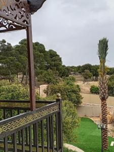 a wooden balcony with a palm tree in the background at Munifah Grand Hills Chalet and Farm in Jurf ad Darāwīsh +16 photos