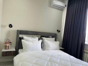 a bedroom with a bed with white sheets and pillows at Арман комфорт in Aktobe