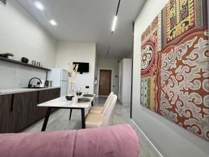 a living room with a table and a painting on the wall at Арман комфорт in Aktobe