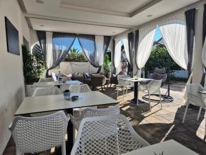 a restaurant with white chairs and tables and windows at Innova TravelVir - Salt and Sun in Vir