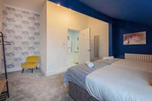 een slaapkamer met een groot bed en een gele stoel bij Stanley-3 Bdrm House Ideal for Contractors Near Beach in Blythe