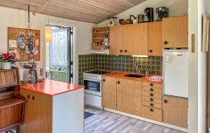a kitchen with white appliances and wooden cabinets at 3 Bedroom Beautiful Home In Hørve in Hørve