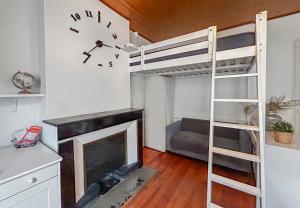 une chambre avec un lit superposé et une cheminée dans l'établissement Vue sur la Bastille Appt Calme et Cosy, à Grenoble
