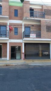 a brick building with two garage doors and a sign at Departamento pequeño y comod in Fernando de la Mora