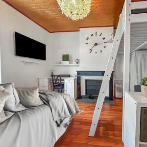 un salon avec un canapé et une horloge au mur dans l'établissement Vue sur la Bastille Appt Calme et Cosy, à Grenoble