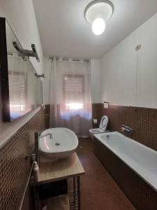 a bathroom with a sink and a tub and a toilet at Affittacamere Vetuliae Foligno in Foligno