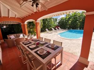 サン・フランソワにあるVilla Alizée charmante villa avec piscineのダイニングルーム(テーブル、椅子付)、スイミングプール