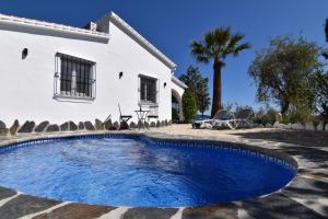 ein Swimmingpool vor einem Haus in der Unterkunft Finca El Corinto -The Enchanted Place in Cómpeta