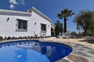 eine Villa mit einem Swimmingpool vor einem Haus in der Unterkunft Finca El Corinto -The Enchanted Place in Cómpeta