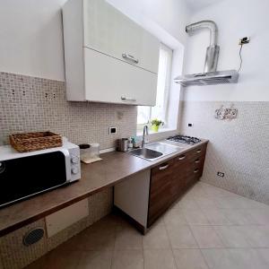 a kitchen with a sink and a microwave at Domus Nicolaus in Giovinazzo