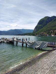 a dock on a body of water with mountains at La Mansardina in Menaggio +5 photos