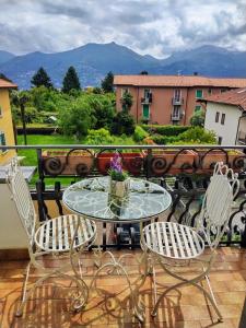 a table and chairs on a balcony with a view at La Mansardina in Menaggio