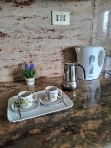 a tray with two cups and a coffee pot on a counter at La Mansardina in Menaggio