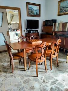 a wooden dining room table with chairs and a television at La Mansardina in Menaggio