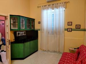 a living room with a green cabinet and a window at A Za' Nella Avola in Avola