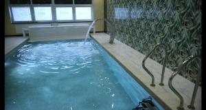 a pool of water with a bench in a building at Marina Jacht Szałkowo in Szałkowo