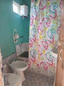 een badkamer met een toilet, een wastafel en een douchegordijn bij Cabaña Anita in Cerrillos