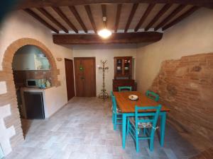 a kitchen with a table and chairs in a room at La casetta sull'arco in Sarteano
