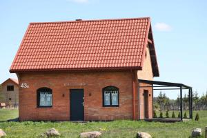 a red brick house with an orange roof at Słoneczny Domek Rostki in Rostki