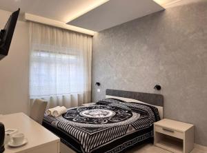 une chambre avec un lit avec une couette noire et blanche dans l'établissement Alla corte degli dei, à Tropea