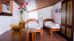 a room with two beds and a table with a vase of flowers at Villa Kaluvi in Skiathos Town