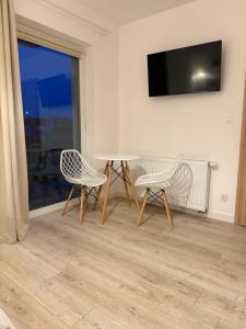 a room with two chairs and a table and a television at Sportowa 10 in Jastarnia