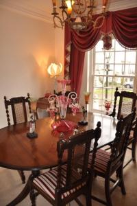 a dining room with a wooden table and chairs at Modern Regency Townhouse London in London